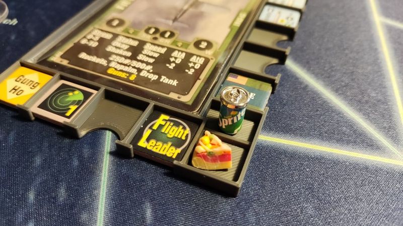 A 3d printed 'Sled' showing a Corsair Leader aircraft with tokens plus lunch.