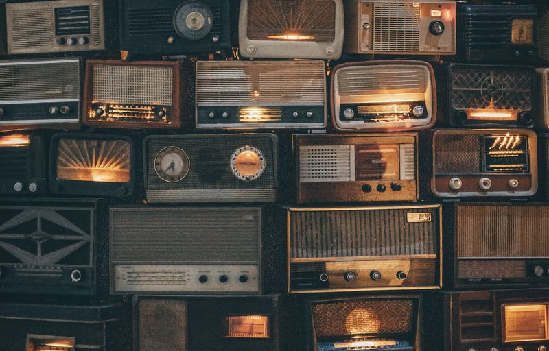 A photograph of a pile of old radios