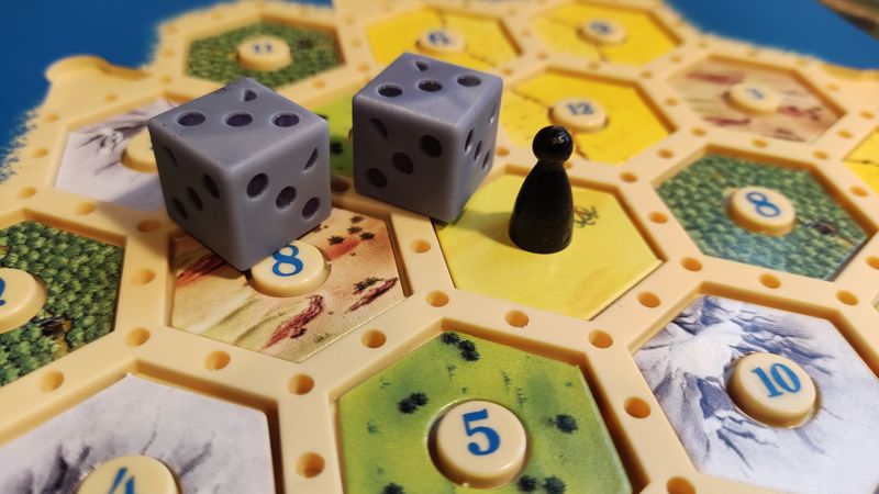 A photograph of a Catan game with 2 d6 dice showing 3.5 pips each.