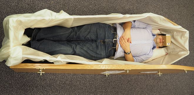 Taphobos in play, a person is wearing VR headset and lying in a coffin