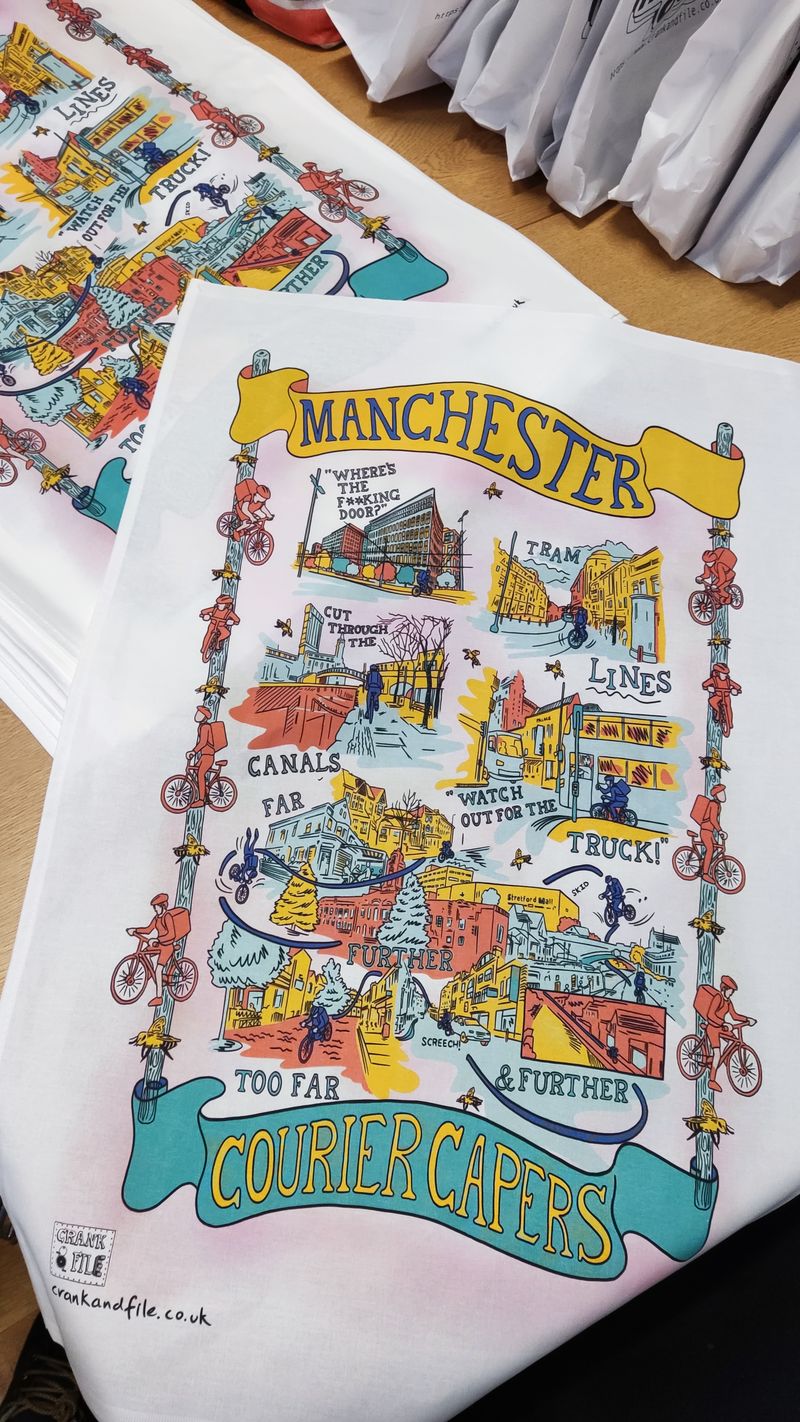 The tea towel for manchester, showing a delivery rider getting into trouble with tram tracks, getting lost in trafford, and other scenes