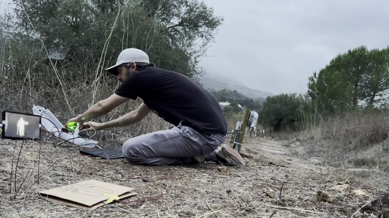 Photograph of Julian, working on one of the stations in the dirt halfway up the hill